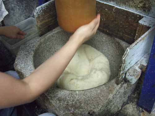 一升餅の作り方（６）　杵にお餅がくっつかないように手水で杵をさわります。